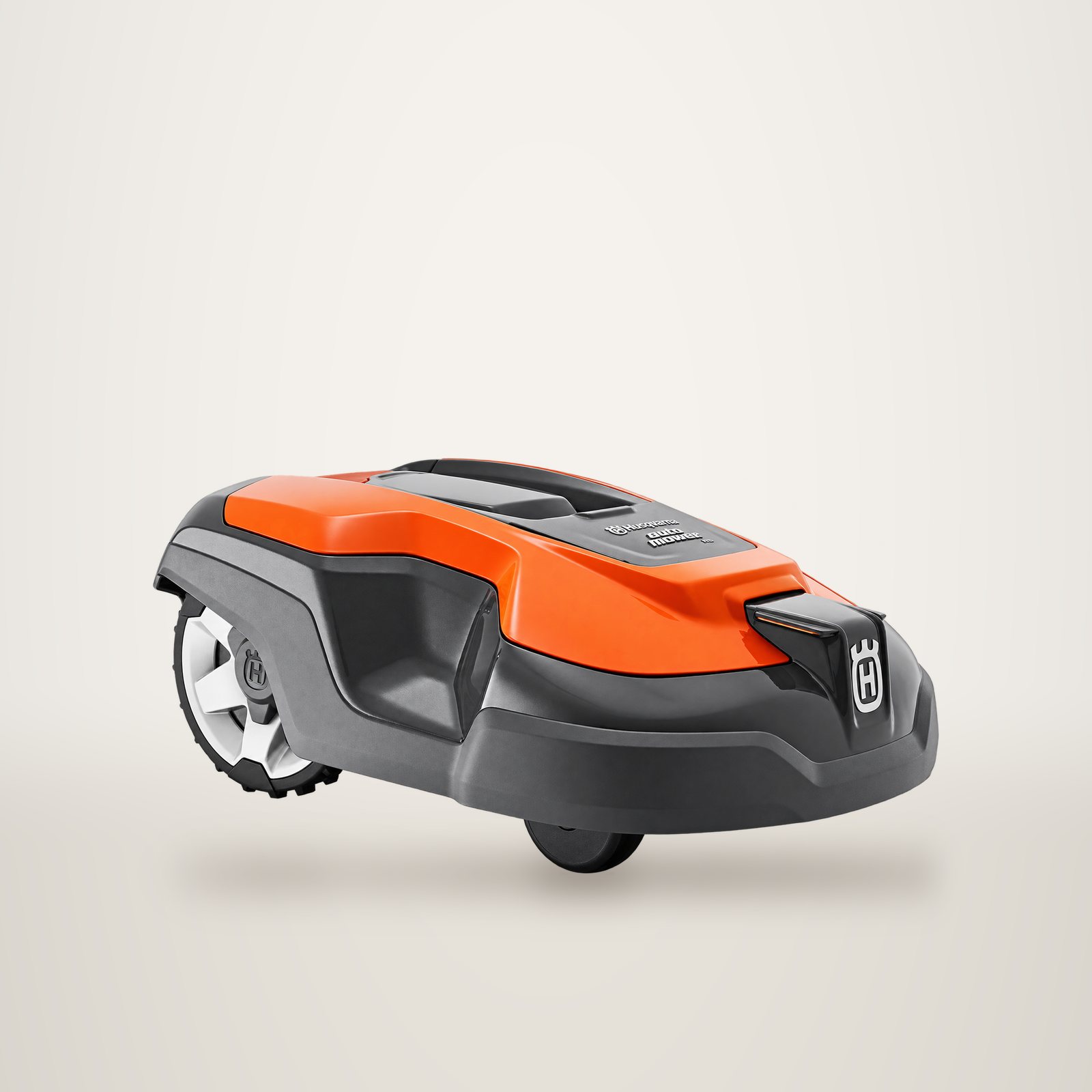 Une tondeuse robot Husqvarna orange et grise, vue de trois quarts avant, sur un fond de studio clair.